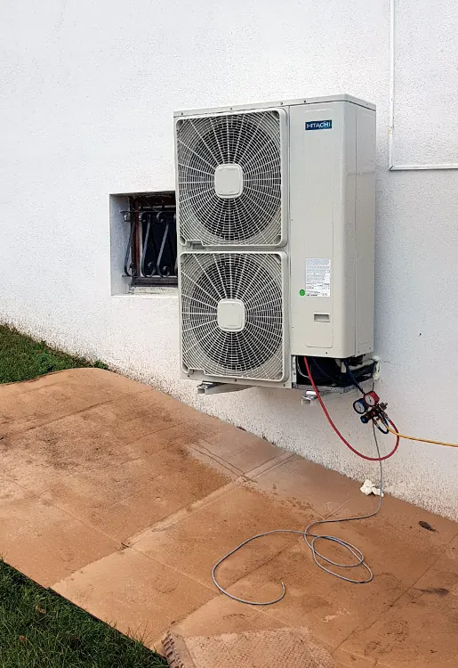 Groupe extérieur de la pompe à chaleur air/eau posé dans le jardin d'une maison à Genas