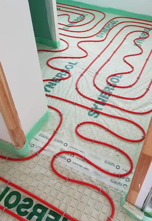 Boucles de plancher chauffant en tubes PER déployées avant chape, rénovation à Sainte-Foy-lès-Lyon